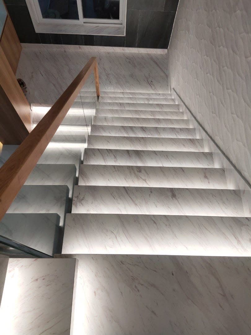 Escalier droit en marbre clair avec éclairage encastré sous chaque marche