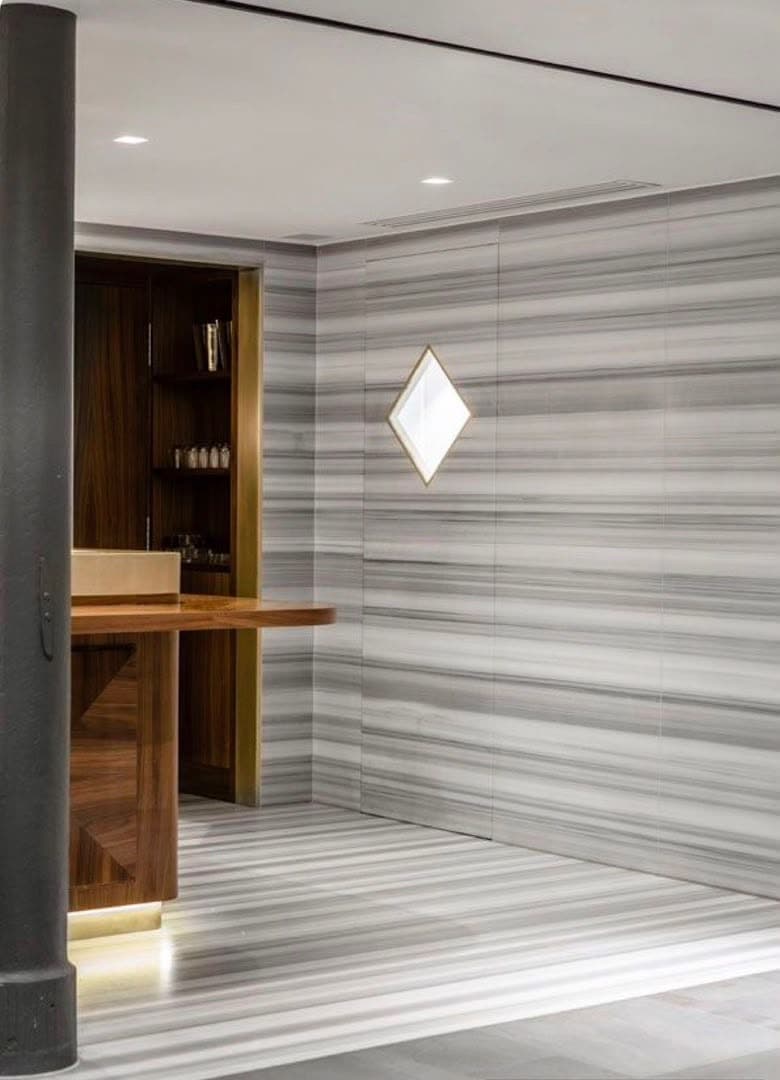 Habillage de mur et de sol en marbre gris rayé, le dessin poursuivi du mur au sol