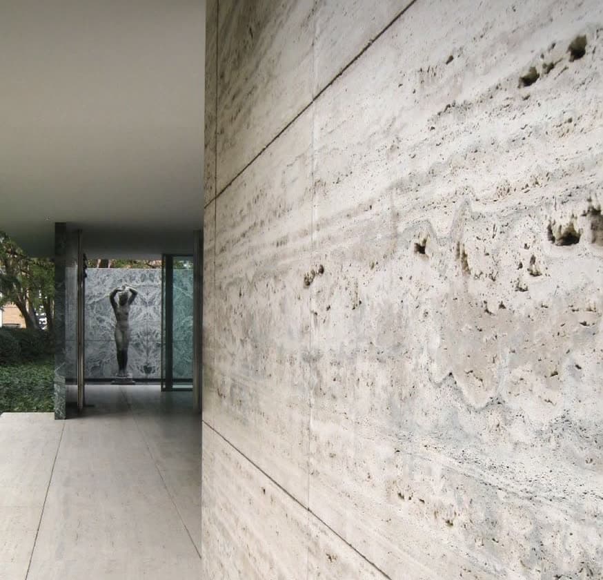 Mur habillé de travertin beige, les lits de la pierre suivis d'une plaque à l'autre