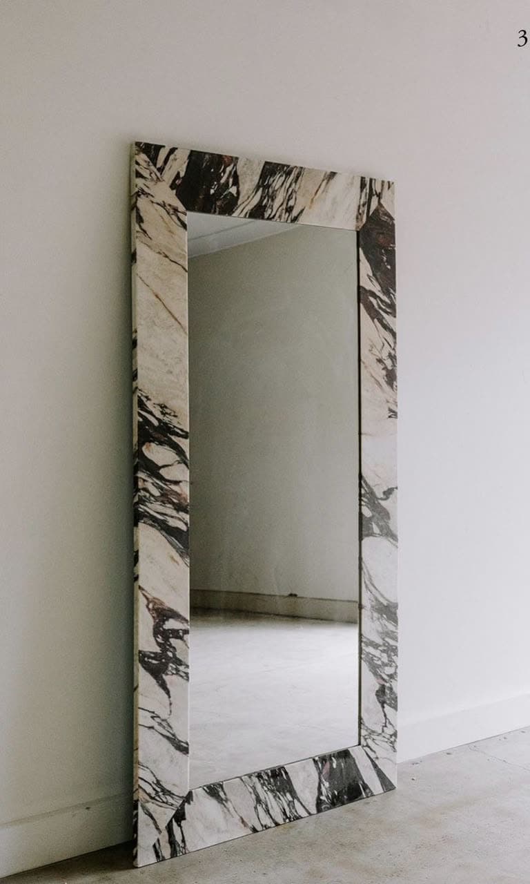 Grand miroir posé au sol, encadrement en plaques de marbre veiné