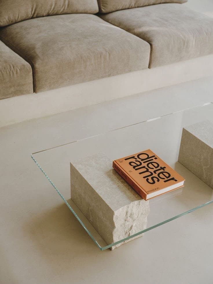 Table basse à plateau de verre posé sur deux blocs de pierre éclatée